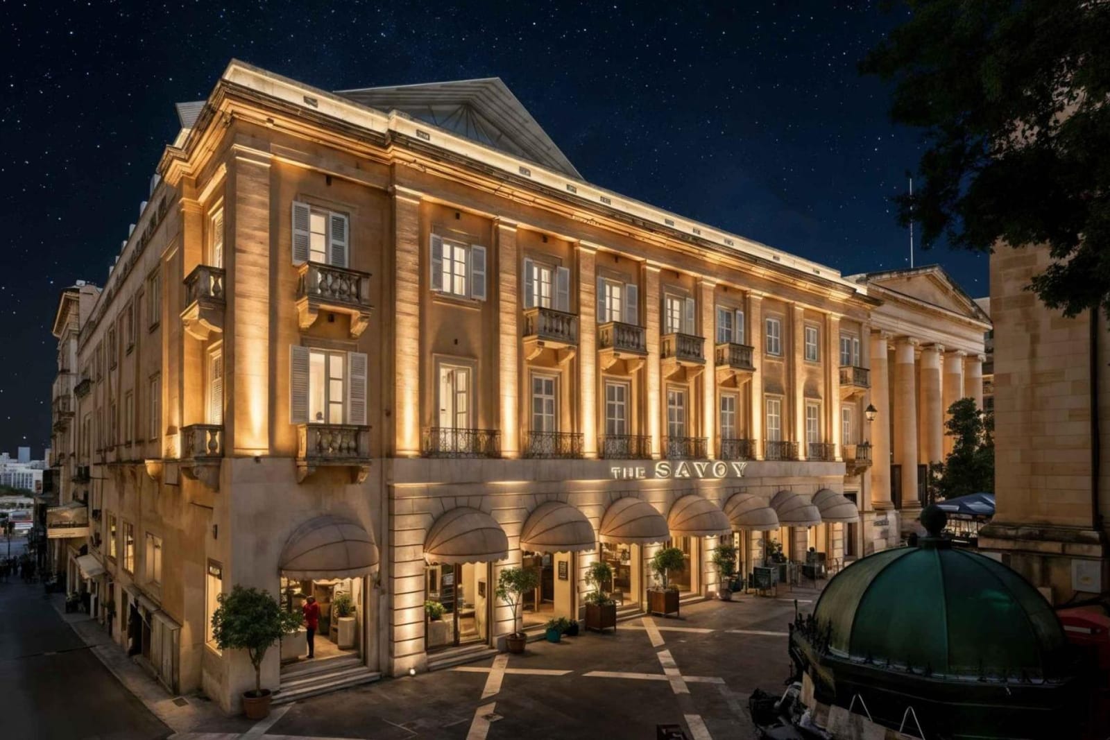 A computer-generated night render of the proposed Savoy hotel in Valletta, its lit facade reading THE SAVOY, with an added top floor, on the Republic Street corner