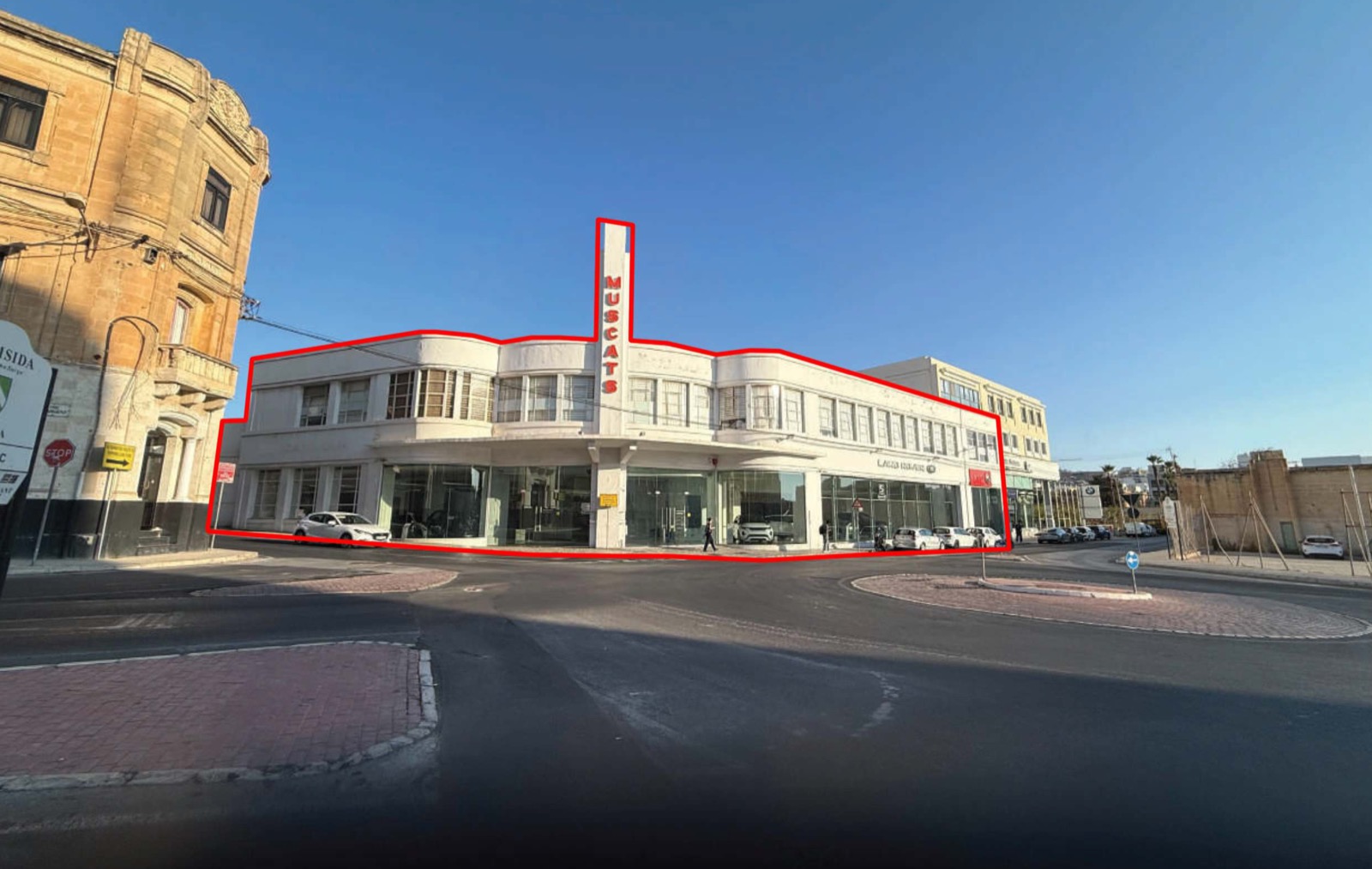 A wide view of the Muscats Motors showroom on its roundabout corner in Gżira, the application site outlined in red.