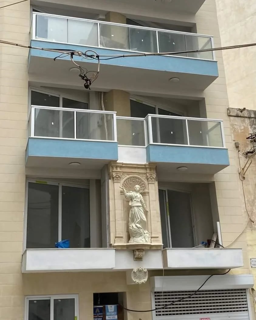 An apartment building with a statue niche and balconies