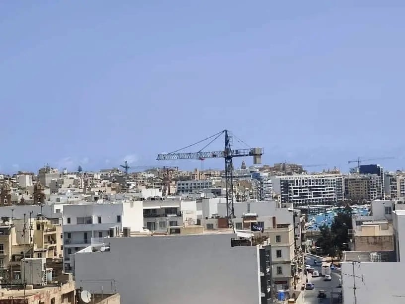 Dense town sprawl punctuated by cranes