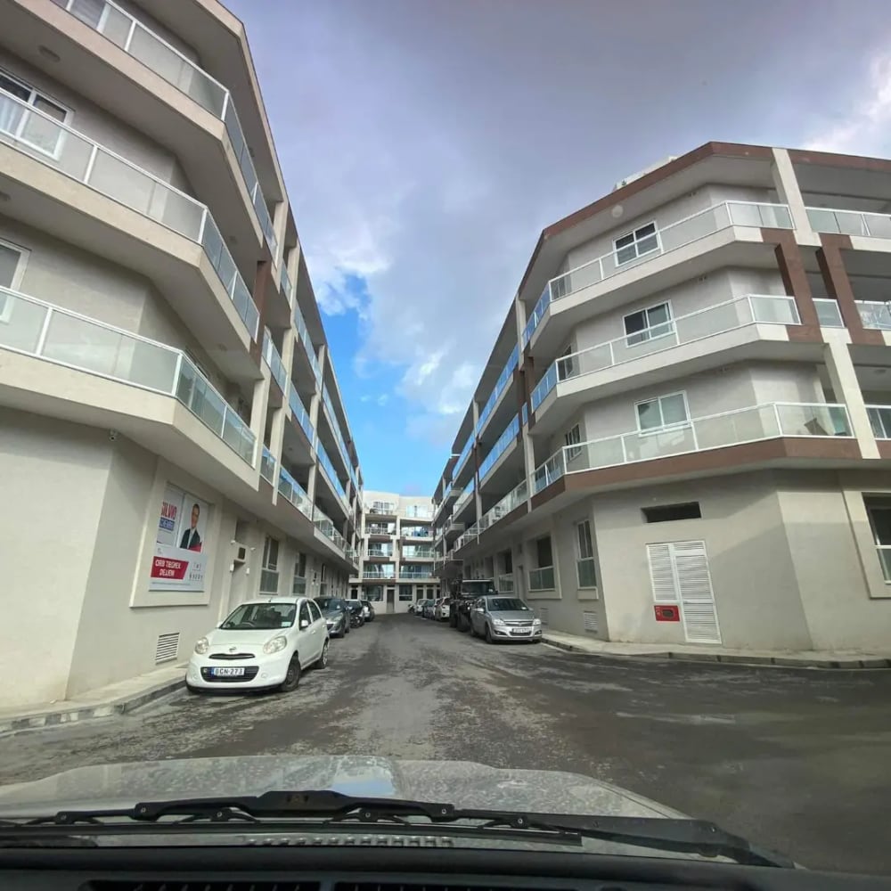 A street canyon of white apartment blocks